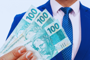 Uma pessoa de terno azul e gravata segura três notas de 100 reais, considerando onde investir 1.000 reais com sabedoria.